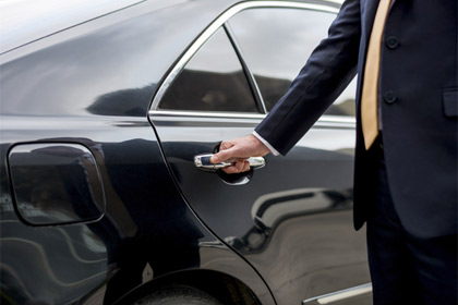 Chauffeur opens the door of a ProLimo sedan